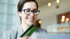 Modern woman with plastic card shopping in web